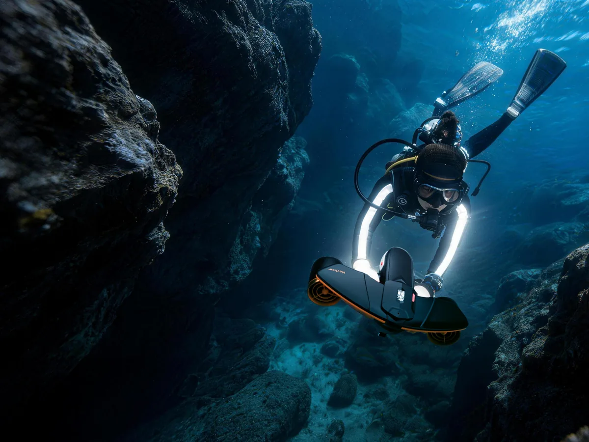 Plongeur en bouteille tracté par un Sublue dans un canyon rocheux
