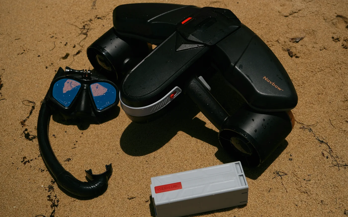 Deux Sublue, un masque, un tuba et une batterie posés sur le sable