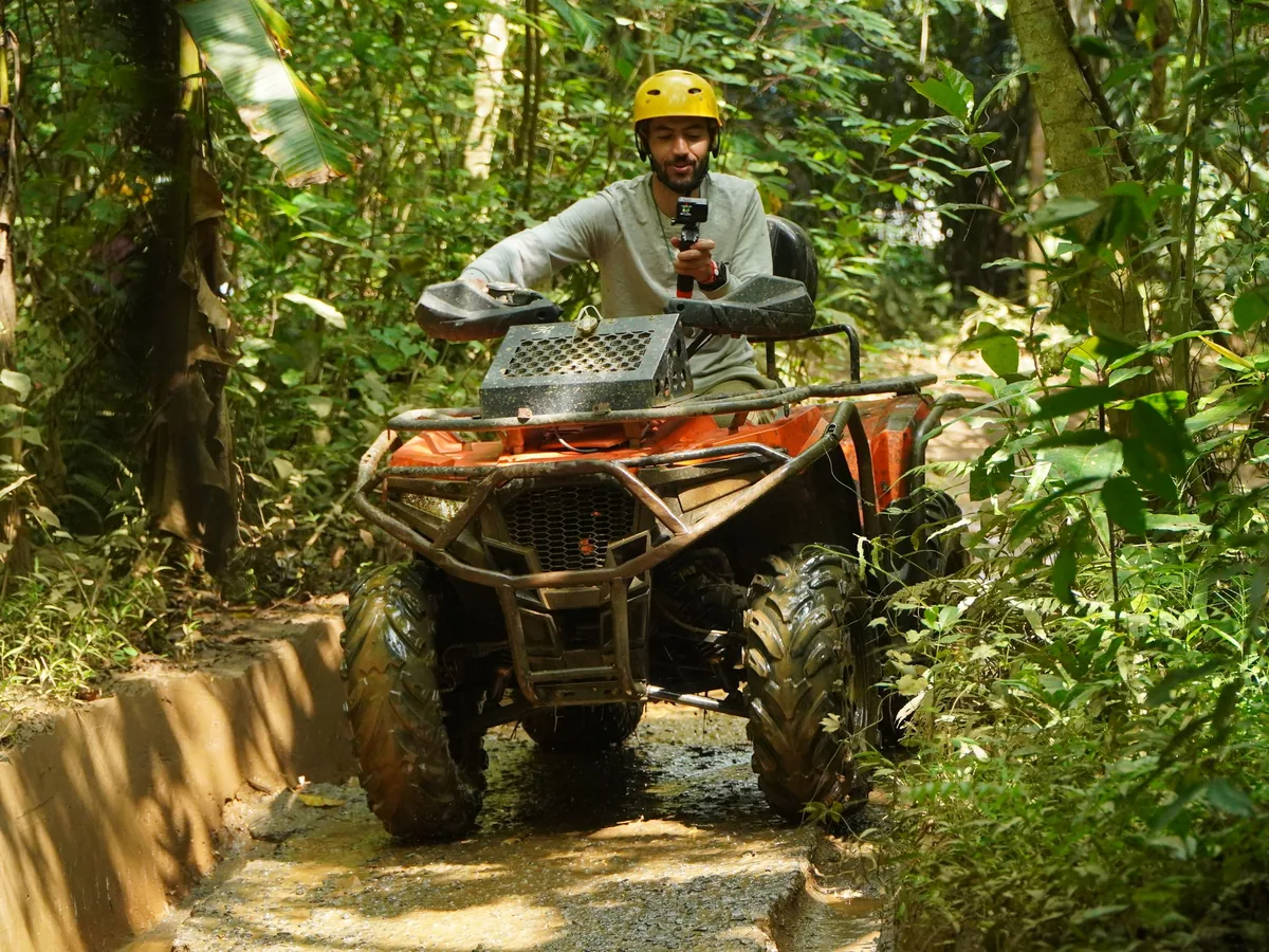 Quad sur une piste boueuse au milieu de la végétation tropicale