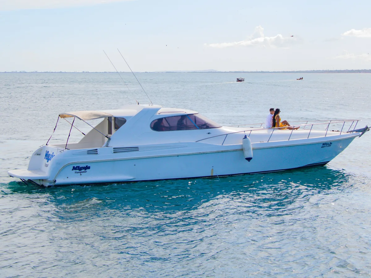 Bateau à moteur privé au mouillage, deux passagers assis à la proue